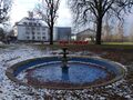 Brunnen unweit des Quelltempels der König-Ludwig-Quelle I auf dem Gelände der heutigen <!--LINK'" 0:5-->, im Hintergrund das <!--LINK'" 0:6-->, Januar 2021