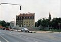 Blick zum Eckgebäude  und <a class="mw-selflink selflink">Schießplatz 24</a>, links der 2. Bauabschnitt der als Lärmschutzwall geplanten Reihenhäuser an der  als Fortsetzung des 1. BA  im Juni 1999