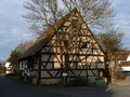 Die unter Denkmalschutz stehende Dorfscheune in Poppenreuth, rings umgeben von Asphalt