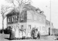 Eckgebäude  182 und  der heutigen Baustoffhandlung , früher Bäckerei. Links Frau Bauer mit den Töchtern Anna, Ida, Babette, rechts Frau Krug mit Kindern, ca. 1900