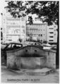 Reste des König-Ludwig-II.-Brunnen im Jahr 1985. Im Hintergrund als Parkplatz genutztes Ruinengrundstück an der Moststraße mit auffälligem Wandbild an Moststr. 33
