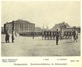 Parademarschübung im Kasernenhof der Artilleriekaserne  – links Mitte das Dienstgebäude (Kasino), daneben die Stallung der I. Abteilung; <br/>im Hintergrund sind der Wasserturm der <!--LINK'" 0:7--> sowie das Mannschaftsgebäude der <!--LINK'" 0:8--> erkennbar (Aufnahme um 1910)