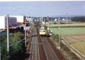 1991:  Aufnahme mit Oberleitungs Bauzug von der Brücke an der <!--LINK'" 0:40--> aus Richtung Bahnhof Vach mit Vor- und Einfahrtsignal, Stellwerk 1 und Bahnübergang nach Steinach. Links das Werksgelände und die große Lagerhalle der Firma <!--LINK'" 0:41-->, im Hintergrund das  Stellwerk 2 am Bahnübergang nach Herboldshof.