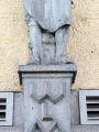 Detailaufnahme von der Eingangsfigur über der ehem. Gaststätte "Zum Bergbräu". Deutlich zu sehen ist neben dem Monogramm WLM (Wilhelm Mailaender) ein kleiner Affe zwischen den Füssen der Figur.