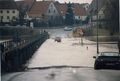 Hochwasser in Vach, Fußgängersteg nach Mannhof, die Brückenstraße unter Wasser mit mutigen Autofahrer Feb. 1987. Heute steht hier der hochgelegte <a class="mw-selflink selflink">Talübergang Brückenstraße</a>