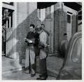 Eigentümer Michael Reichel im Gespräch mit einem US-Miltärangehörigen vor der Firma Reifen-Reichel in der Langen Straße, 1950